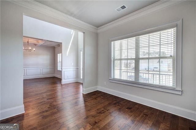 unfurnished room with visible vents, ornamental molding, wainscoting, a chandelier, and hardwood / wood-style flooring