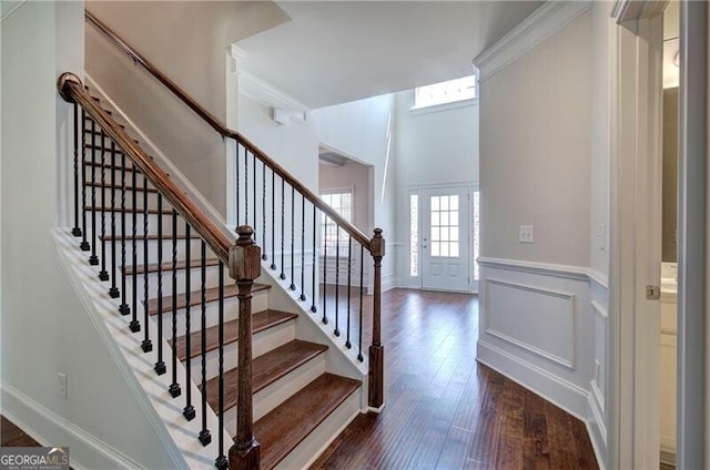 stairway featuring hardwood / wood-style flooring and wainscoting