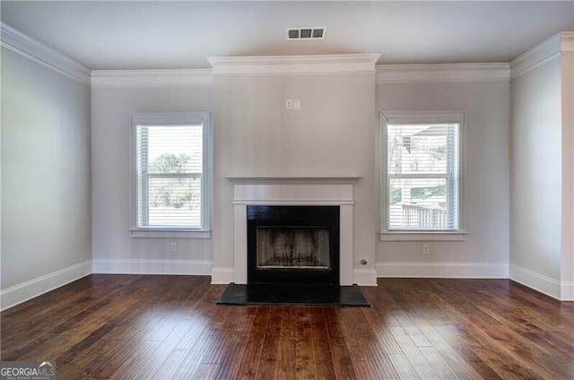 unfurnished living room featuring baseboards, visible vents, a fireplace with raised hearth, crown molding, and hardwood / wood-style flooring