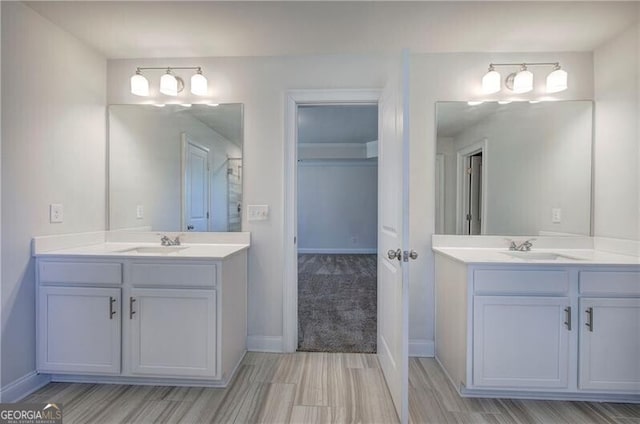 bathroom with two vanities, a sink, and baseboards