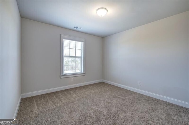 unfurnished room featuring baseboards, visible vents, and carpet flooring