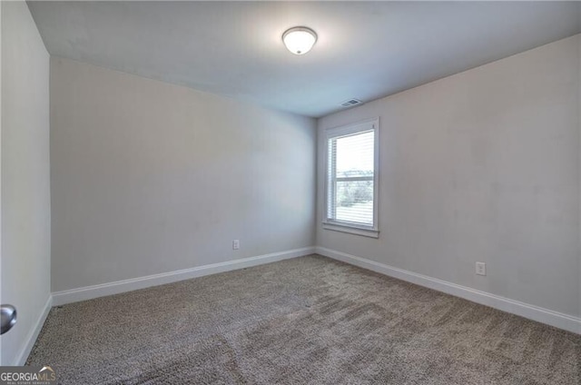unfurnished room with visible vents, baseboards, and carpet floors
