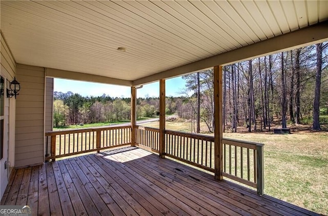 wooden terrace featuring a yard