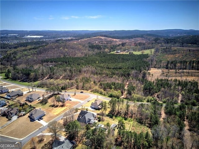 drone / aerial view with a forest view and a mountain view