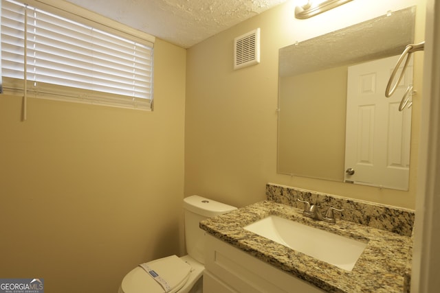 4183 Northstrand Dr, Decatur, GA 30035 - half bath featuring a textured ceiling, visible vents, toilet, and vanity
