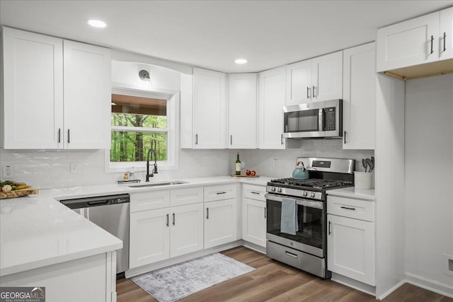 3951 Covered Bridge Rd SW, Smyrna, GA 30082 - kitchen with appliances with stainless steel finishes, a sink, backsplash, white cabinets, and recessed lighting