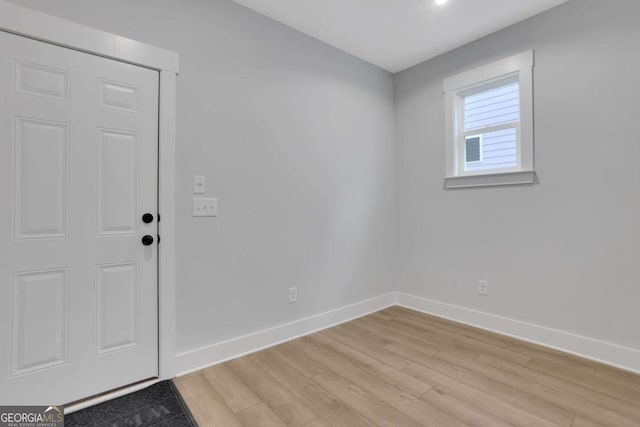 unfurnished room with light wood finished floors and baseboards