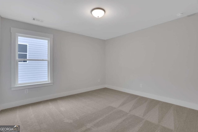 spare room with baseboards, visible vents, and carpet flooring