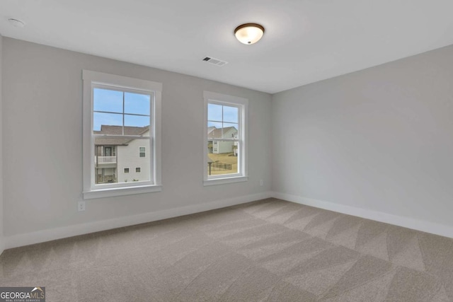 unfurnished room with baseboards, visible vents, and carpet floors