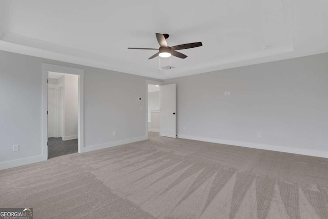 carpeted empty room featuring baseboards and ceiling fan