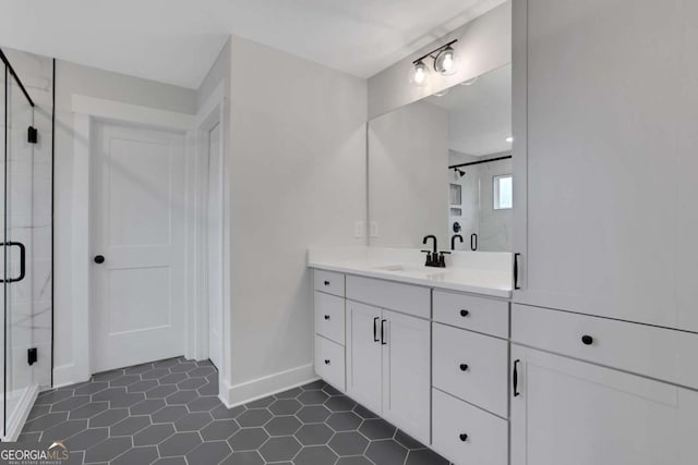 bathroom with a shower stall, tile patterned floors, baseboards, and vanity
