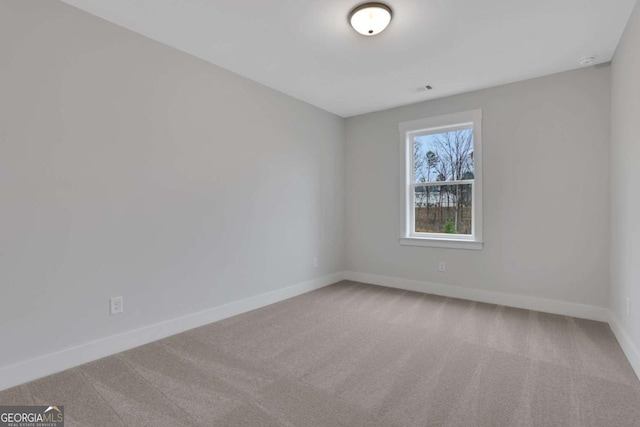 carpeted empty room featuring baseboards