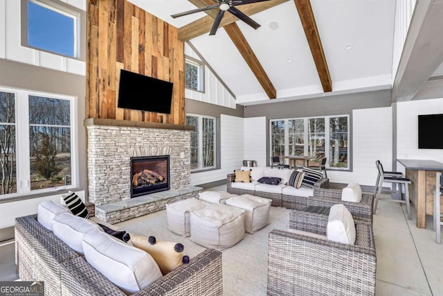 living room featuring high vaulted ceiling, wood walls, a fireplace, ceiling fan, and beam ceiling