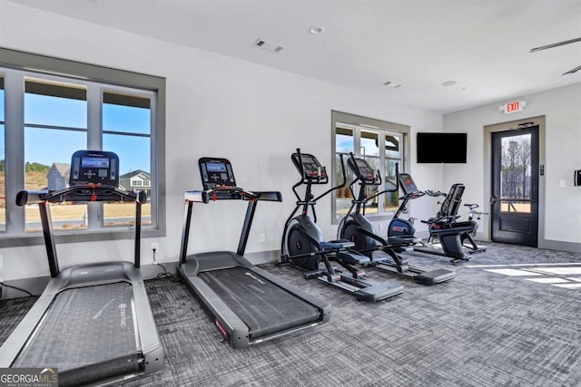 exercise room featuring baseboards, visible vents, and carpet floors