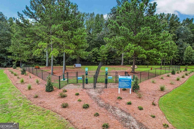 view of home's community with a gate, fence, and a yard