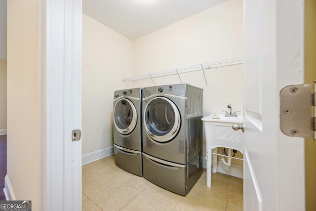 washroom featuring baseboards, laundry area, tile patterned floors, and washer and clothes dryer