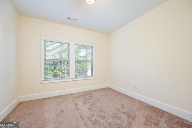 carpeted empty room with baseboards and visible vents