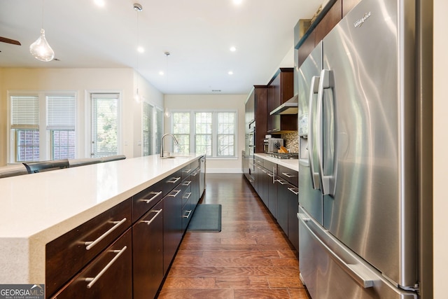 kitchen featuring stainless steel fridge with ice dispenser, recessed lighting, light countertops, and a sink