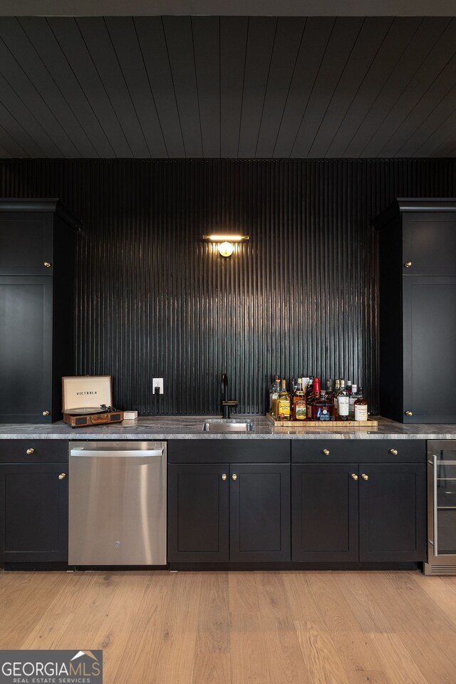 kitchen featuring custom exhaust hood, a breakfast bar, light wood-style flooring, backsplash, and high end range