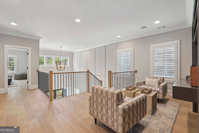living room featuring visible vents, light wood finished floors, an inviting chandelier, ornamental molding, and recessed lighting