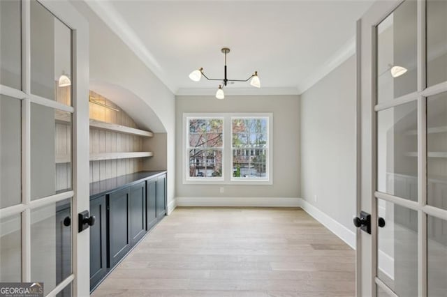 2587 Apple Valley Rd, Brookhaven, GA 30319 - unfurnished dining area featuring french doors, a chandelier, crown molding, and light wood-type flooring