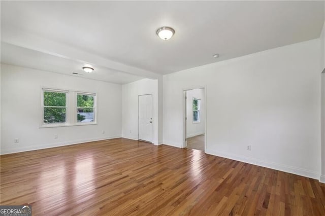 empty room featuring wood finished floors and baseboards