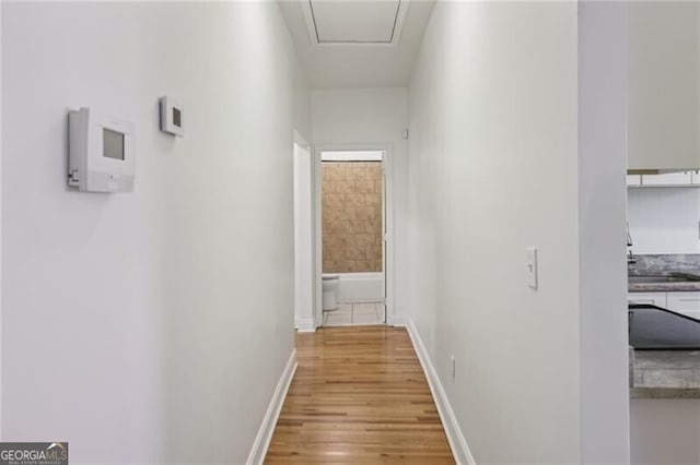 hall with light wood finished floors and baseboards