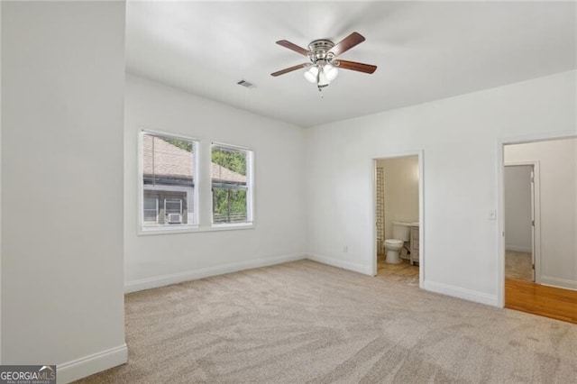 unfurnished bedroom featuring connected bathroom, carpet floors, visible vents, and baseboards
