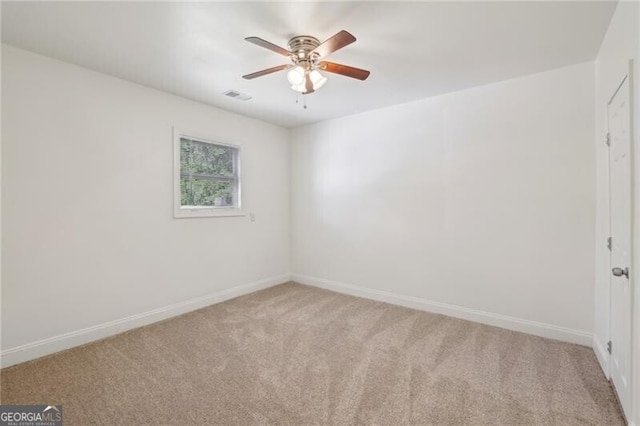 empty room featuring baseboards, a ceiling fan, visible vents, and light colored carpet