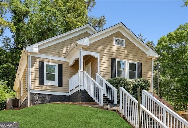 bungalow-style house featuring central AC unit and a front yard