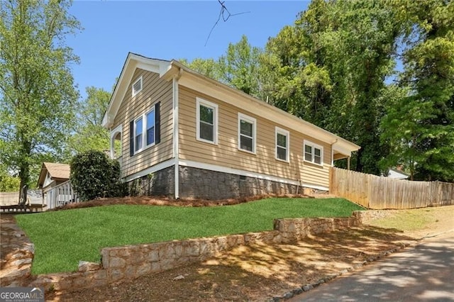view of side of property with a yard and fence