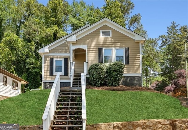 bungalow-style house featuring a front yard and stairway