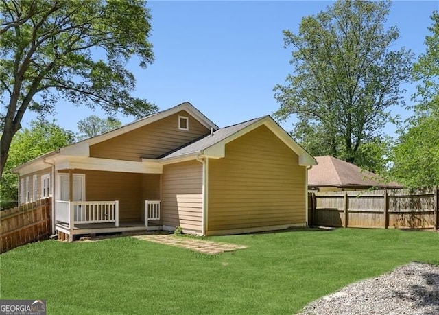 rear view of property with a lawn, a wooden deck, and fence