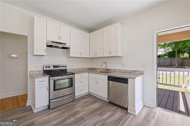 kitchen featuring a sink, white cabinets, appliances with stainless steel finishes, dark wood finished floors, and under cabinet range hood