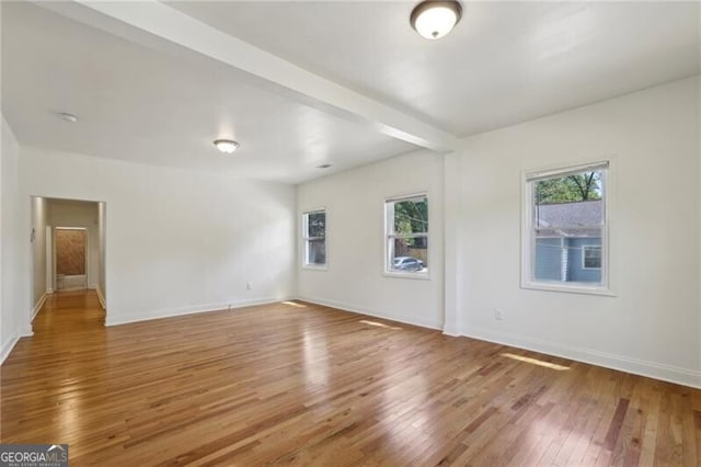 empty room with baseboards and hardwood / wood-style floors