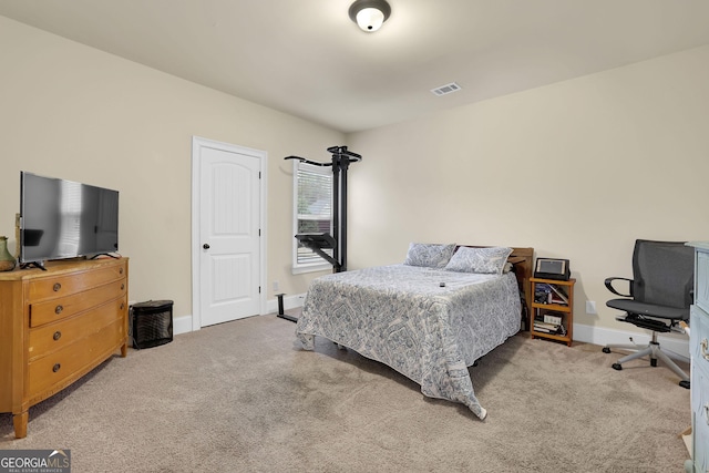 bedroom featuring baseboards, visible vents, and carpet