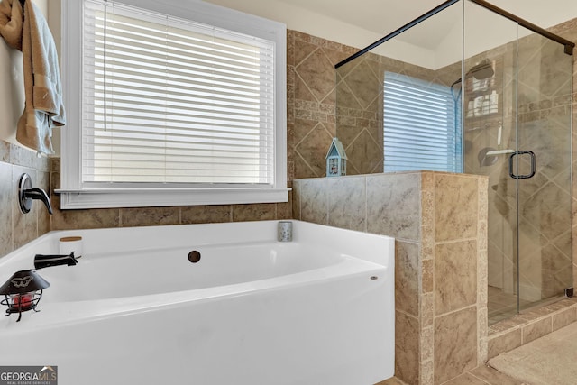 bathroom with a stall shower and a bath