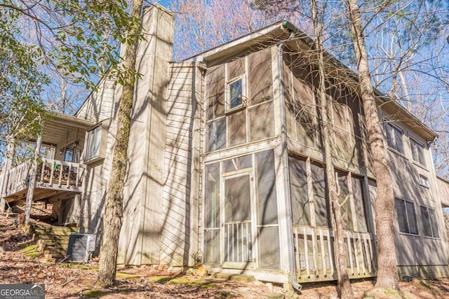 200 Villa Rd Unit 103, Jasper, GA 30143 - view of side of property with a chimney, central air condition unit, a wooden deck, and a sunroom