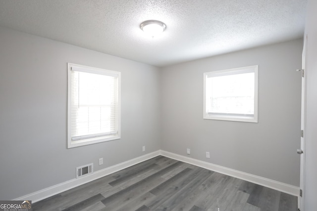3363 Wesley Chapel Rd, Decatur, GA 30034 - spare room with baseboards, dark wood-style flooring, a textured ceiling, and visible vents