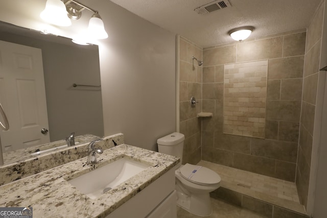 3363 Wesley Chapel Rd, Decatur, GA 30034 - full bathroom with a tile shower, toilet, vanity, a textured ceiling, and visible vents