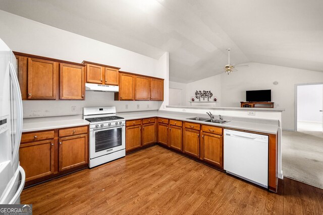 57 Sorghum Ct, Dallas, GA 30157 - kitchen with white appliances, a sink, lofted ceiling, brown cabinets, and under cabinet range hood