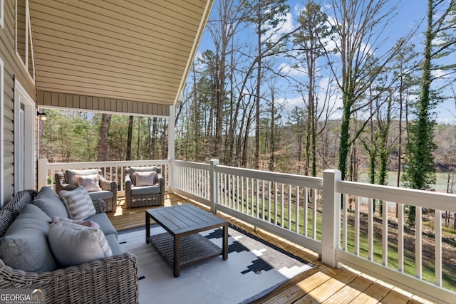 deck with outdoor lounge area and a view of trees