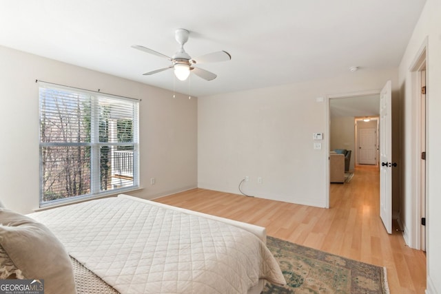 bedroom featuring baseboards, light wood-style floors, and ceiling fan