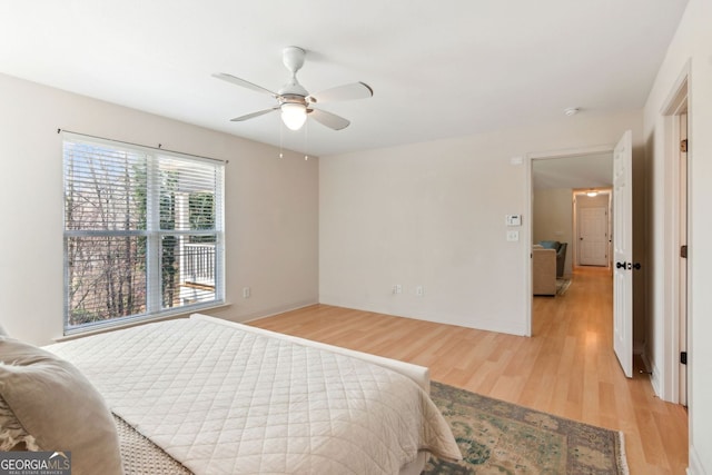 bedroom with baseboards, light wood-style flooring, and ceiling fan