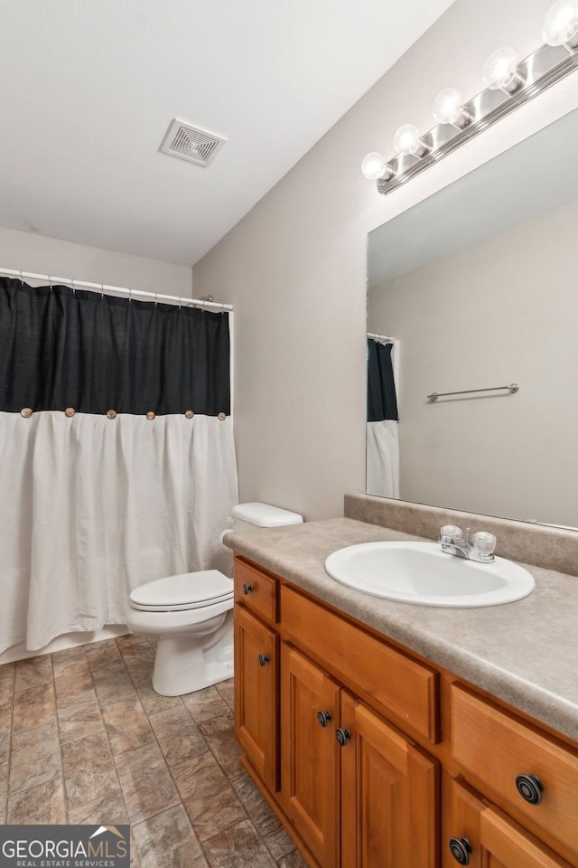 bathroom with visible vents, toilet, and vanity