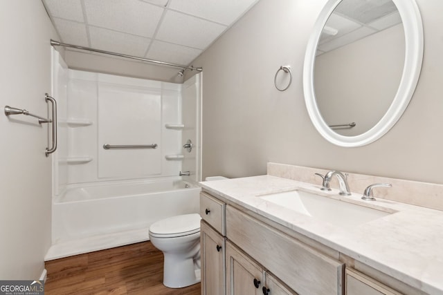 bathroom featuring a drop ceiling, toilet, vanity, and wood finished floors