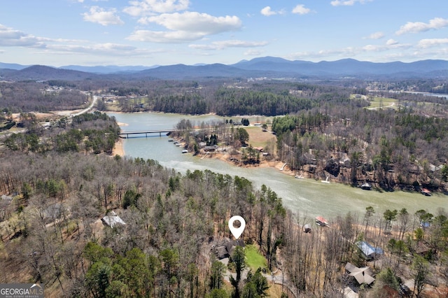 bird's eye view featuring a wooded view and a water and mountain view
