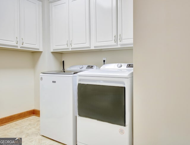 clothes washing area featuring light tile patterned flooring, washer and dryer, cabinet space, and baseboards