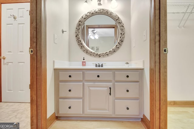 bathroom with a ceiling fan, vanity, and baseboards