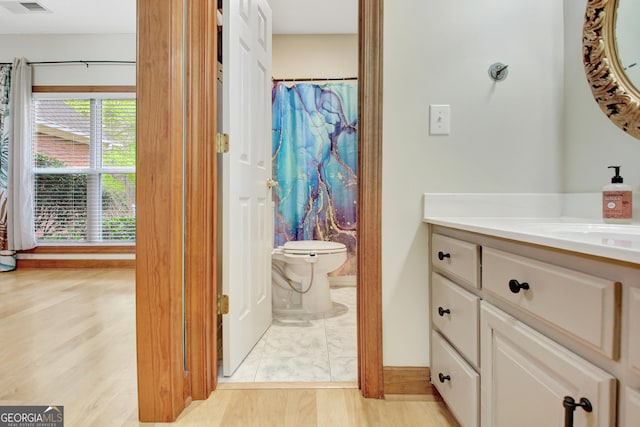 full bathroom featuring visible vents, a shower with shower curtain, toilet, wood finished floors, and vanity